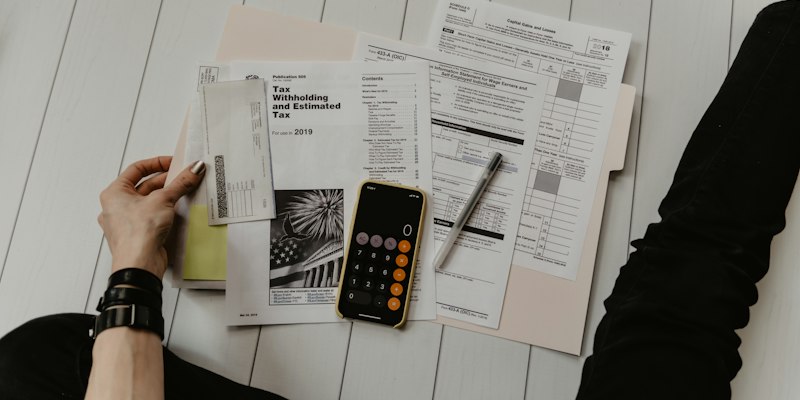 Formulários de impostos, calculadora e caneta sobre a mesa
