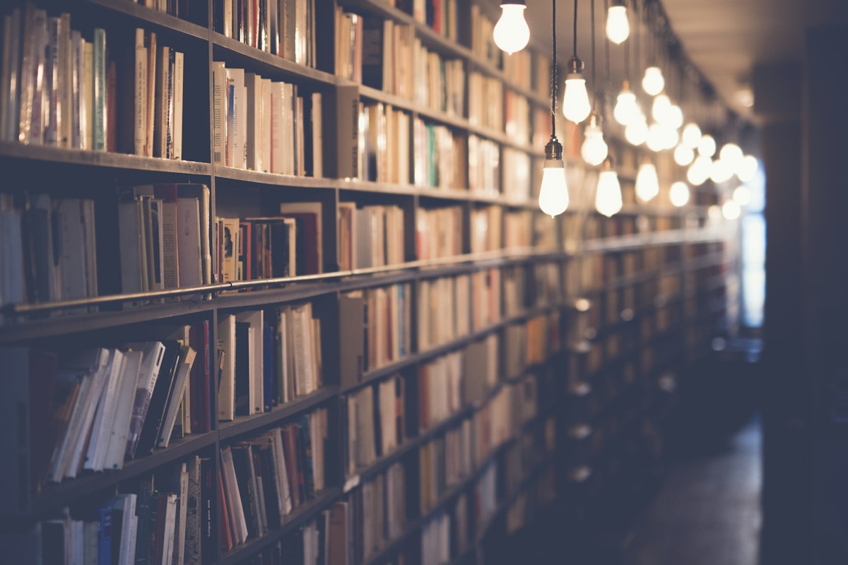 Estantes com livros iluminadas por lâmpadas